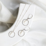 Sterling silver necklace with a circular pendant featuring three fresh water pearls suspended by a delicate beaded chain. 