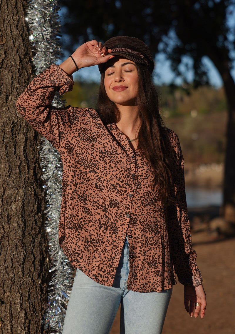[Color: Hazel Black] Button up blouse in an abstract animal print. An elegant style featuring a flattering oversize relaxed fit, a button cuff wrist, and a breezy double keyhole detail at the back. Pair it with jeans for a casual vibe, or dress it up with a skirt for a bohemian chic look. 