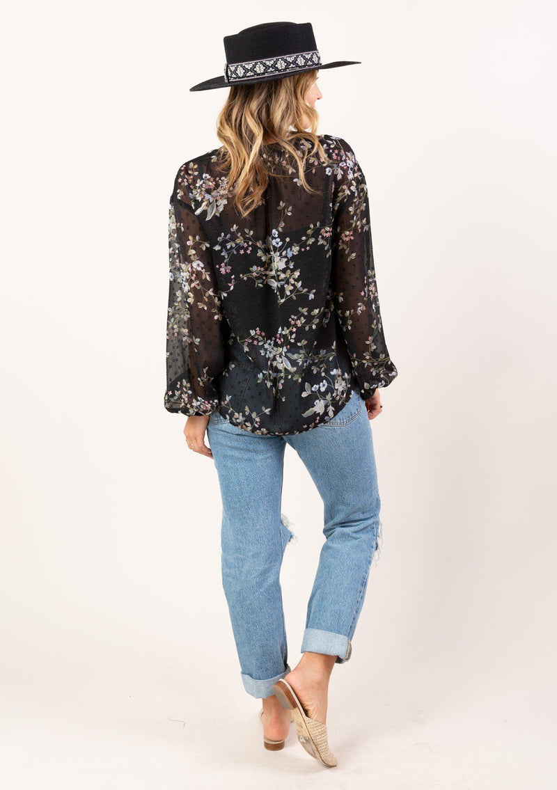 [Color: Black Slate] You will look totally adorable in our gorgeous bohemian blouse in a sheer floral clip dot chiffon. A perfect all season style that features flattering long voluminous sleeves with a flirty ruffle wrist cuff, a button up front with elegant self covered buttons, and button loop details along the v neckline. 