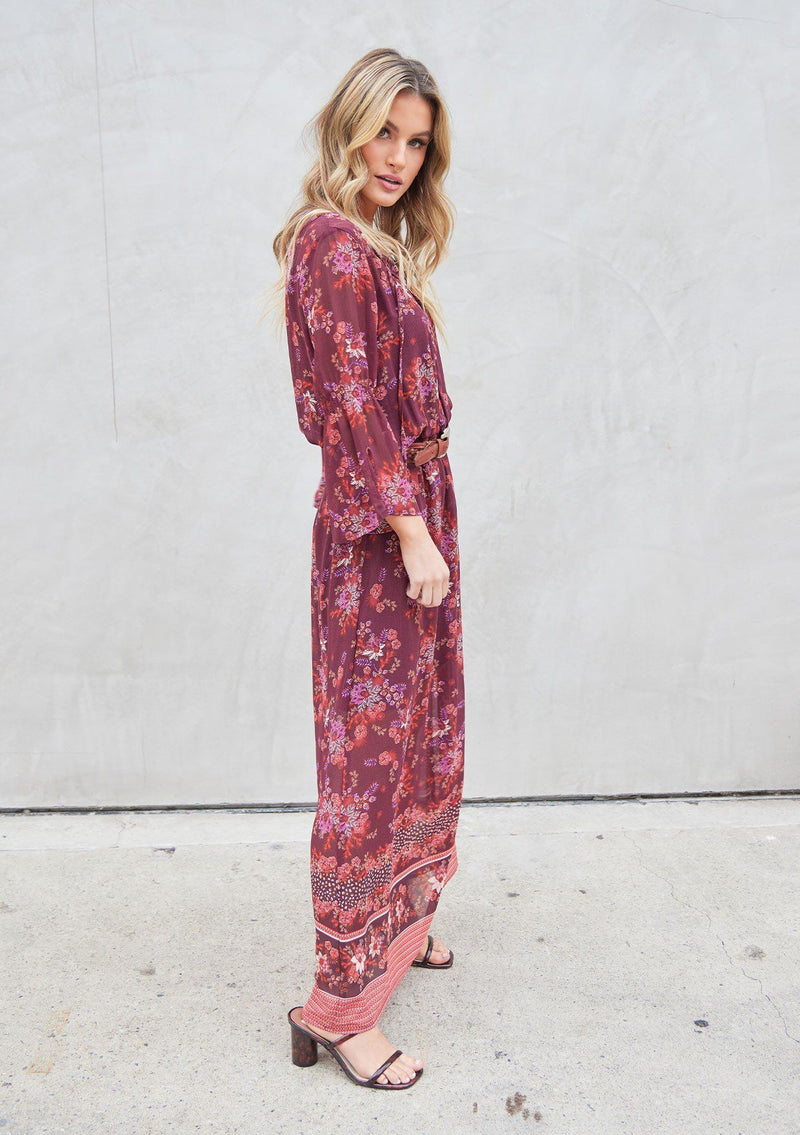 [Color: Wine Spice] A bohemian maxi dress in pretty mixed florals. Featuring a split v neckline with ties, a cinched elastic waist, and long bell sleeves with a split cuff.