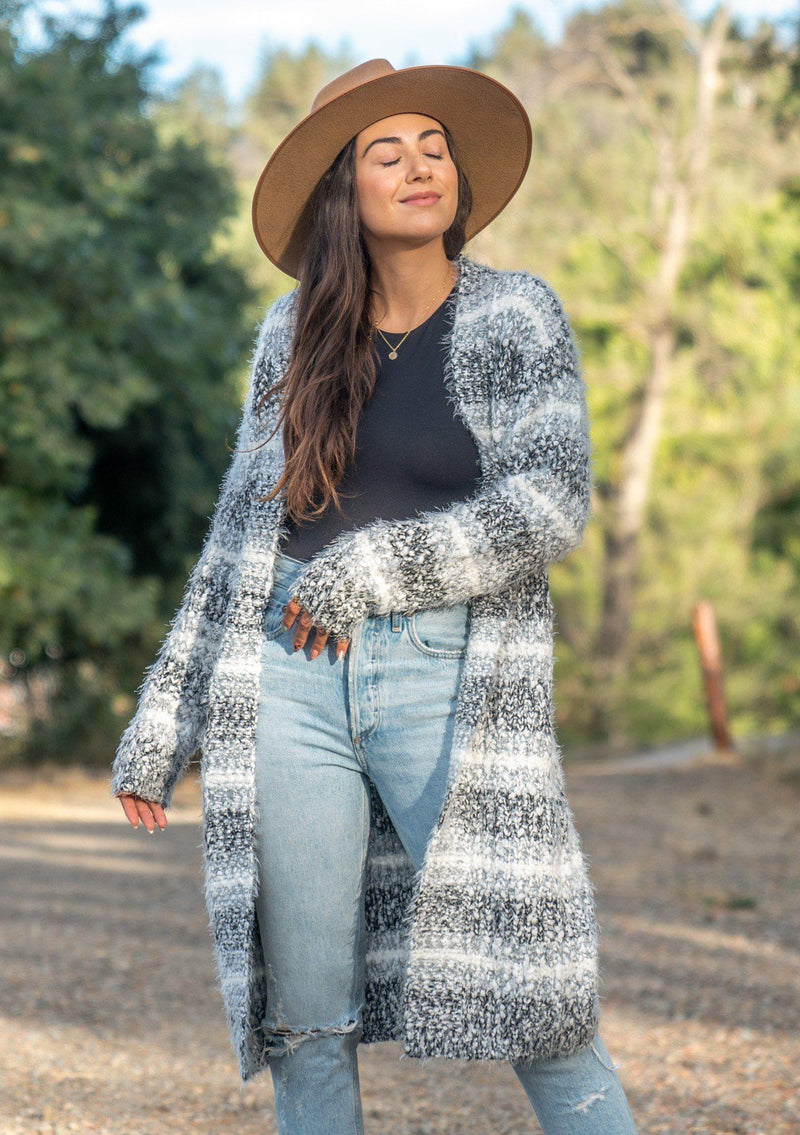 [Color: Black White Sky] An ultra fuzzy mid length cardigan in soft stripes. Features essential side pockets and an open front. Styled here with denim and camel boots for a classic Fall vibe. 