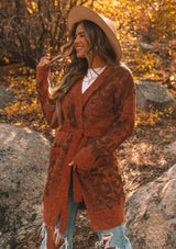 [Color: Heather Rust Bronze] A beautiful metallic jacquard wrap cardigan. Featuring a wrap front with a waist defining belted tie closure and essential side pockets. A beautiful statement sweater with light catching metallic details.