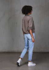 [Color: Mushroom] An ultra soft tie front top, featuring front flap patch pockets, button tab rolled sleeves and a trendy tie front detail. Paired here with denim.