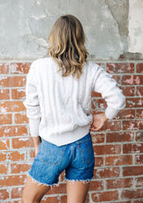 [Color: Light Taupe] A gorgeous cable knit pullover featuring whimsical pom pom details, a warm mock neck, and a contrast ribbed trim.