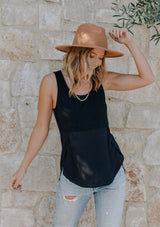 [Color: Black] Girl wearing a mixed media black sleeveless tank top with a scoop neckline.