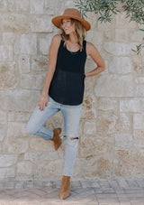 [Color: Black] Girl wearing a mixed media black sleeveless tank top with a scoop neckline.