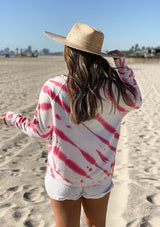 [Color: White Hibiscus] A woman on the beach wearing a soft and cozy tie dye sweatshirt. This cozy pullover features long raglan sleeves and a classic crew neckline. A great option for working from home.