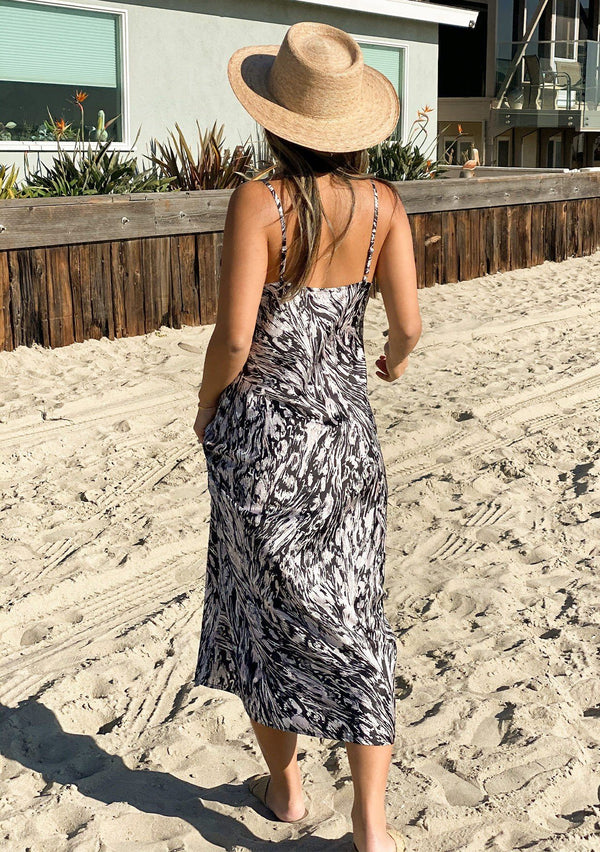 [Color: Grey] Girl at the beach wearing an abstract print silky midi slip dress.