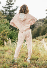 [Color: Blush/Natural] Girl wearing pink tropical print lounge jogger pants.