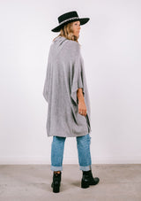 [Color: Heather Grey] Super soft knit sweater poncho. Featuring a shawl collar neckline with functional shank buttons, a front kangaroo pocket, and contrast ribbed trim. 