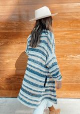 [Color: Blue Natural] A retro striped mid length cardigan. Featuring essential side pockets and subtle metallic details throughout that catch the light. Paired here with jeans and boots.