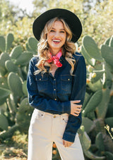 [Color: Dark Indigo] A classic denim blue button up shirt, featuring two front patch pockets with a button flap closure, a snap button up front, and a western style yoke. A staple button up style that pairs effortlessly with white denim. Worn here with a red bandana.