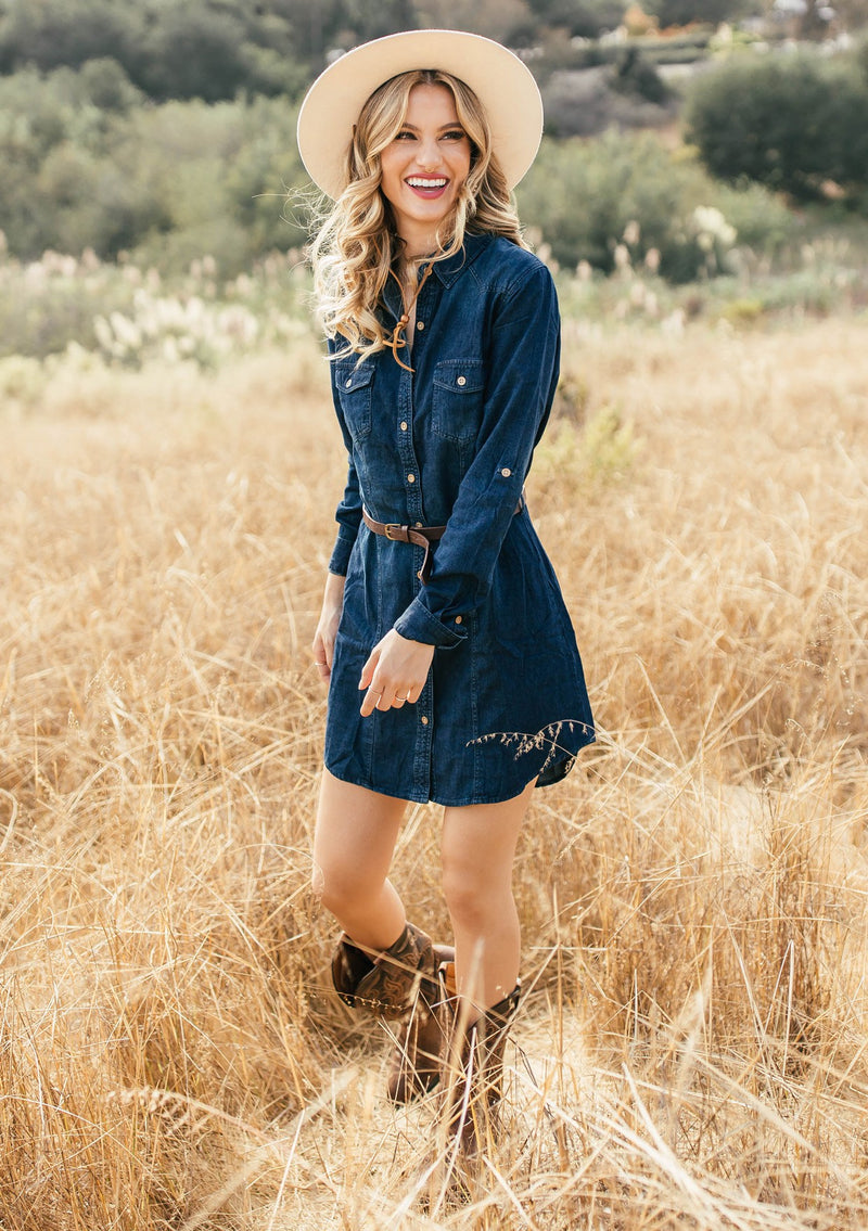 [Color: Dark Indigo Wash] Your Fall wardrobe needs this classic shirtdress in a faded denim wash. Featuring long roll tab sleeves, a waist defining belt, and an easy relaxed fit. Worn here with cowboy boots. 