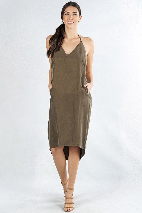 [Color: Olive] A front facing image of a brunette model wearing an olive high low halter dress with a v-neckline, side pockets, and an open back with tie detail. 