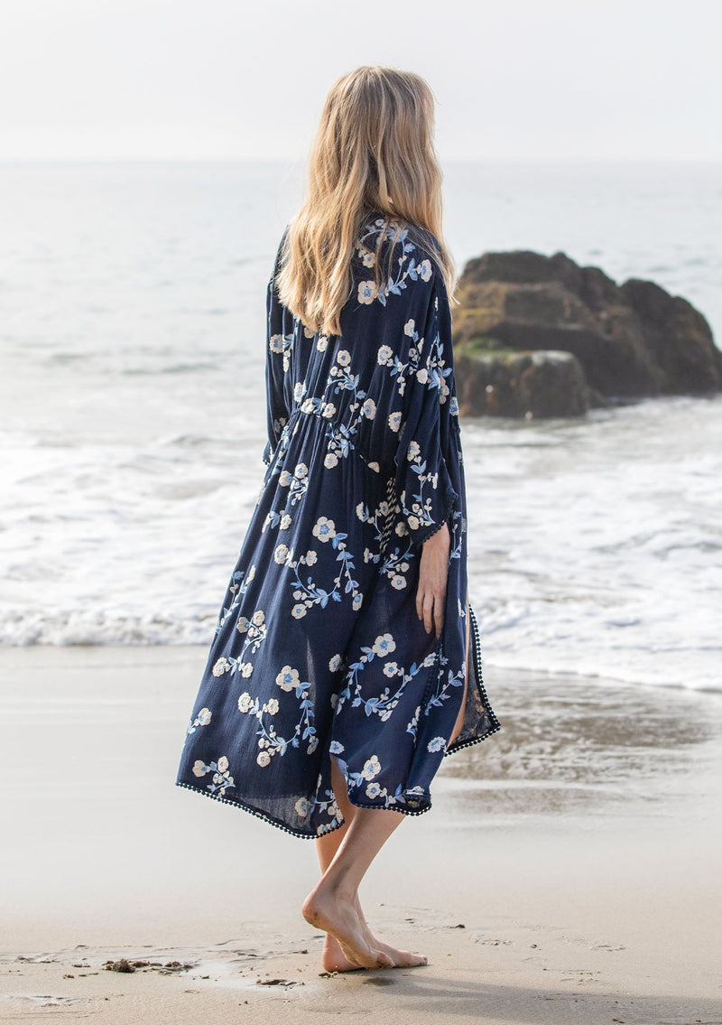 [Color: Navy/Ivory] A model wearing a bohemian navy blue mid length kimono with floral embroidery.