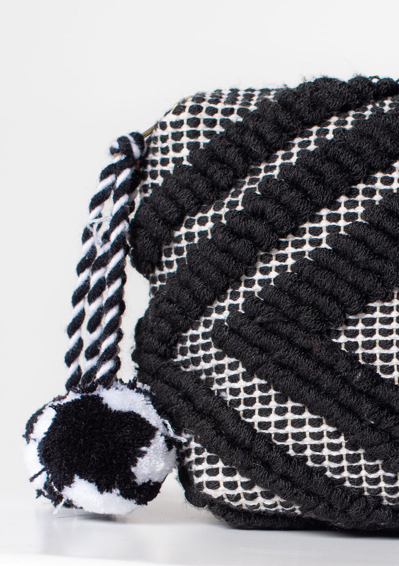 [Color: Black/White] A black and white bohemian carpet makeup bag with pom tassel. 