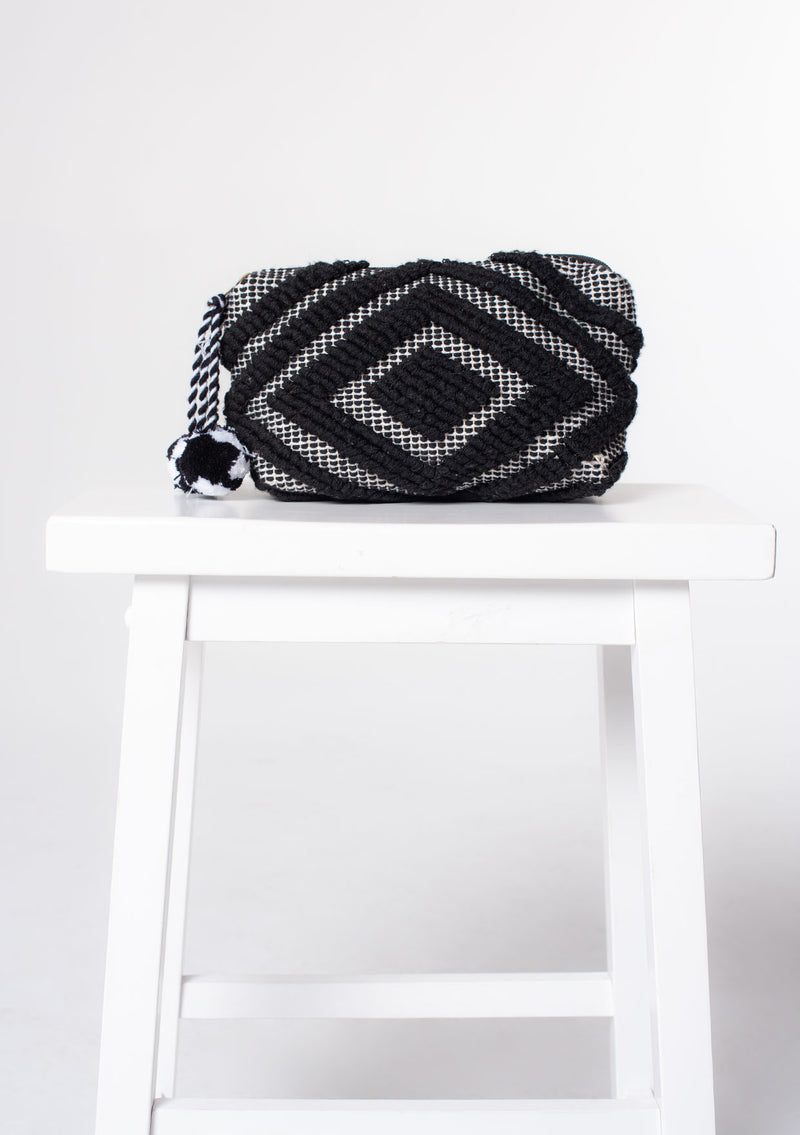 [Color: Black/White] A black and white bohemian carpet makeup bag with pom tassel. 