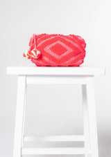 [Color: NeonPink/Natural] A neon pink bohemian carpet makeup bag with pom tassel. 