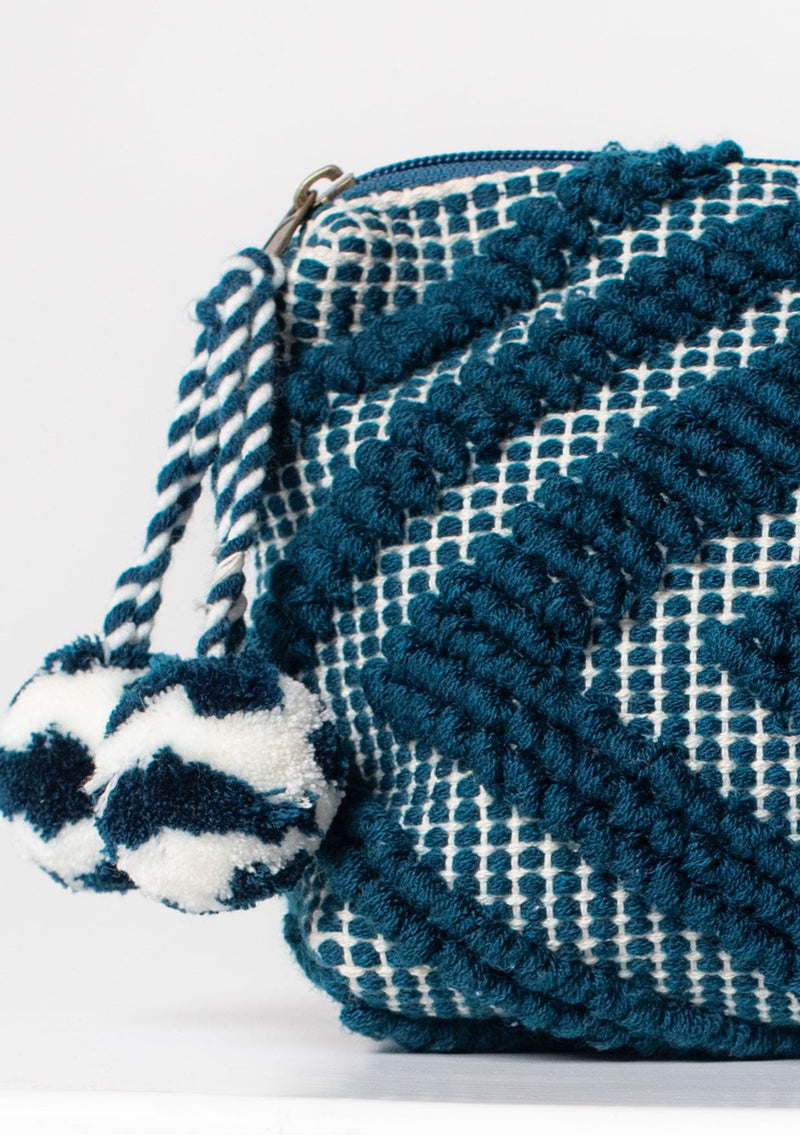[Color: Ocean/Natural] A blue bohemian carpet makeup bag with pom tassel. 