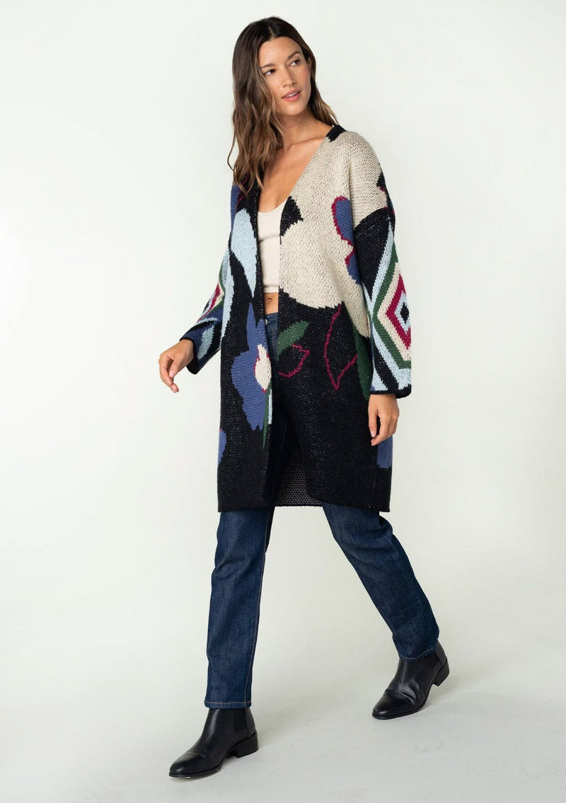 [Color: Navy Multi] A front facing image of a brunette model wearing a warm fall bohemian mid length cardigan in a multicolor large floral jacquard design. With long sleeves and an open front. 