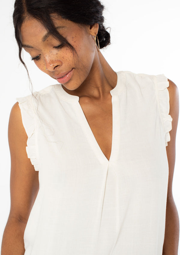 [Color: Natural] A close up front facing image of a black model wearing a natural, off white linen blend bohemian top with short ruffled cap sleeves, a v neckline, and a flowy silhouette. 