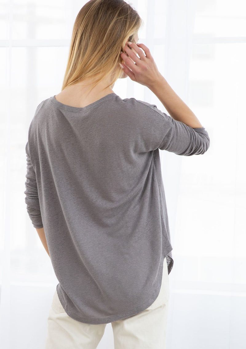 [Color: Smoke] A blond model wearing a linen blend long sleeve tee. Featuring a dropped shoulder and a wide crew neckline.