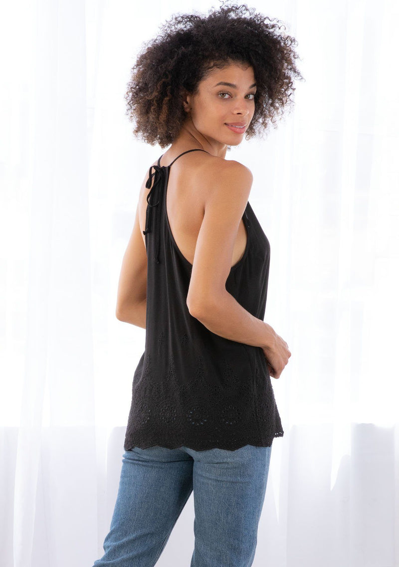 [Color: Black] A model wearing a lightweight tank top with embroidered eyelet detail. With a scalloped hemline, a racer back, and a v neckline.