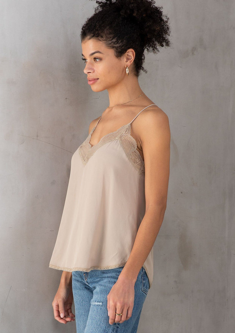 [Color: Stone] A model wearing a timeless silky taupe lace trim camisole, perfect for layering or on its own. With a flattering v neckline and sexy racerback.