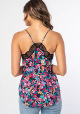 [Color: Black/Fuchsia] A woman wearing a black and pink floral print camisole with contrast black lace trim and adjustable spaghetti straps. 