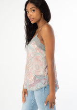 [Color: Blush/Aqua] A side facing image of a black model wearing a sheer pink and aqua blue paisley print chiffon camisole tank top with a lace trim v neckline, adjustable spaghetti straps, and a lace trim racer back. 