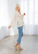 [Color: Vanilla] A model wearing a soft sheer kimono top in a tonal shadow stripe. With long voluminous sleeves, elastic wrist cuffs, and a wrap tie front that can be tied in multiple ways. 