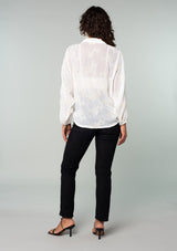 [Color: Ivory] A back facing image of a brunette model wearing an ivory white bohemian embroidered chiffon kimono top. With long sleeves and a tie front that can be styled in multiple ways. 