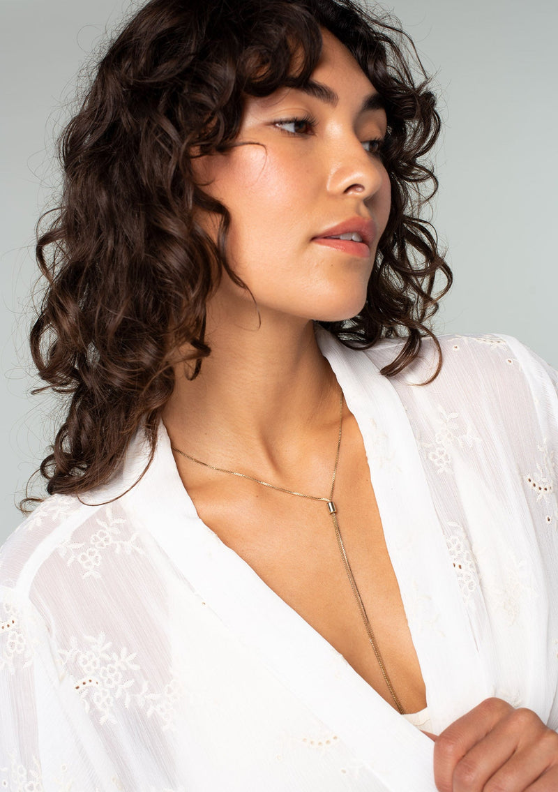[Color: Ivory] A close up front facing image of a brunette model wearing an ivory white bohemian embroidered chiffon kimono top. With long sleeves and a tie front that can be styled in multiple ways. 