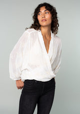 [Color: Ivory] A half body front facing image of a brunette model wearing an ivory white bohemian embroidered chiffon kimono top. With long sleeves and a tie front that can be styled in multiple ways. 