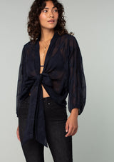 [Color: Navy] A half body front facing image of a brunette model wearing a navy blue bohemian embroidered chiffon kimono top. With long sleeves and a tie front that can be styled in multiple ways. 
