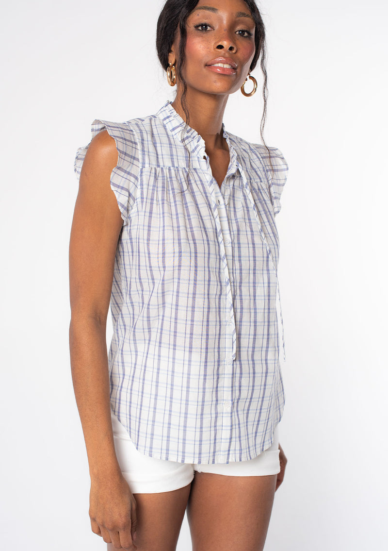 [Color: Natural/Navy] A woman wearing a blue and off white plaid button front top with short flutter sleeves and ruffled trim. 