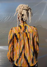 [Color: Honey Gold] A button up blouse in a vintage inspired tile print. Featuring a flirty ruffle yoke detail and a split neckline with ties. A subtle metallic detail throughout adds a little sparkle to this bohemian top. 