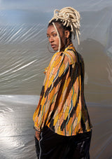 [Color: Honey Gold] A button up blouse in a vintage inspired tile print. Featuring a flirty ruffle yoke detail and a split neckline with ties. A subtle metallic detail throughout adds a little sparkle to this bohemian top. 