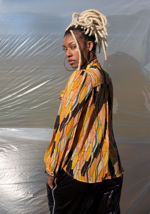 [Color: Honey Gold] A button up blouse in a vintage inspired tile print. Featuring a flirty ruffle yoke detail and a split neckline with ties. A subtle metallic detail throughout adds a little sparkle to this bohemian top. 