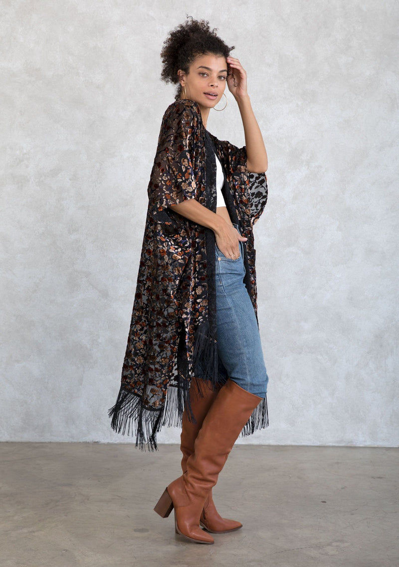 [Color: Rust Multi] A sultry, sheer velvet burnout floral kimono featuring side slits and a long fringe hemline. A bohemian cover up. 