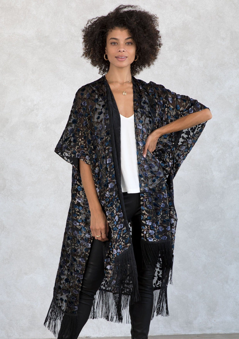 [Color: Black/BlueMulti] A sultry, sheer velvet burnout floral kimono featuring side slits and a long fringe hemline. A bohemian cover up.