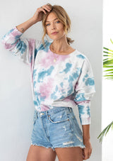 [Color: Rose/Blue Combo] A woman wearing a soft French terry sweatshirt in a bold tie dye wash. Featuring long raglan sleeves and a classic crew neckline. 