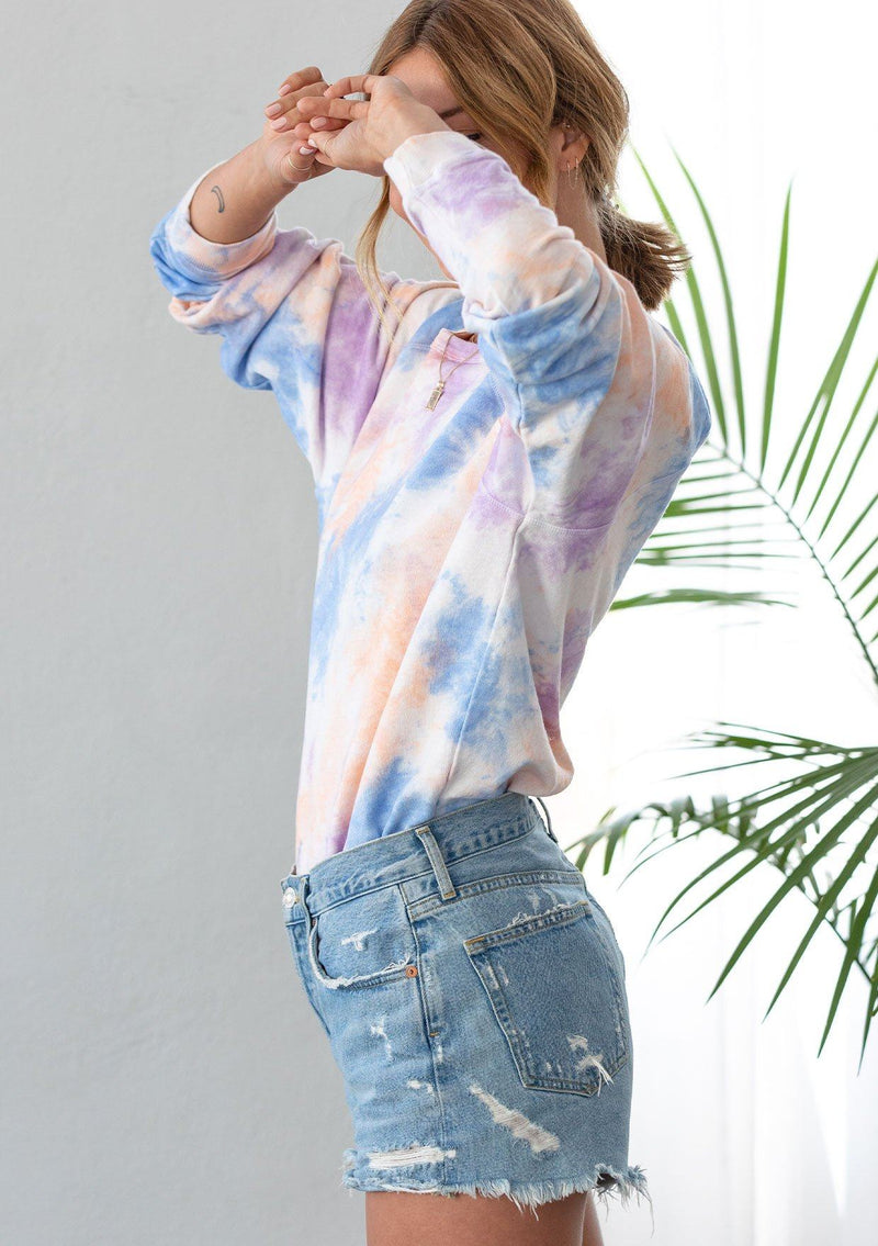[Color: Orange/Blue Combo] A woman wearing a soft French terry sweatshirt in a bold tie dye wash. Featuring long raglan sleeves and a classic crew neckline. 