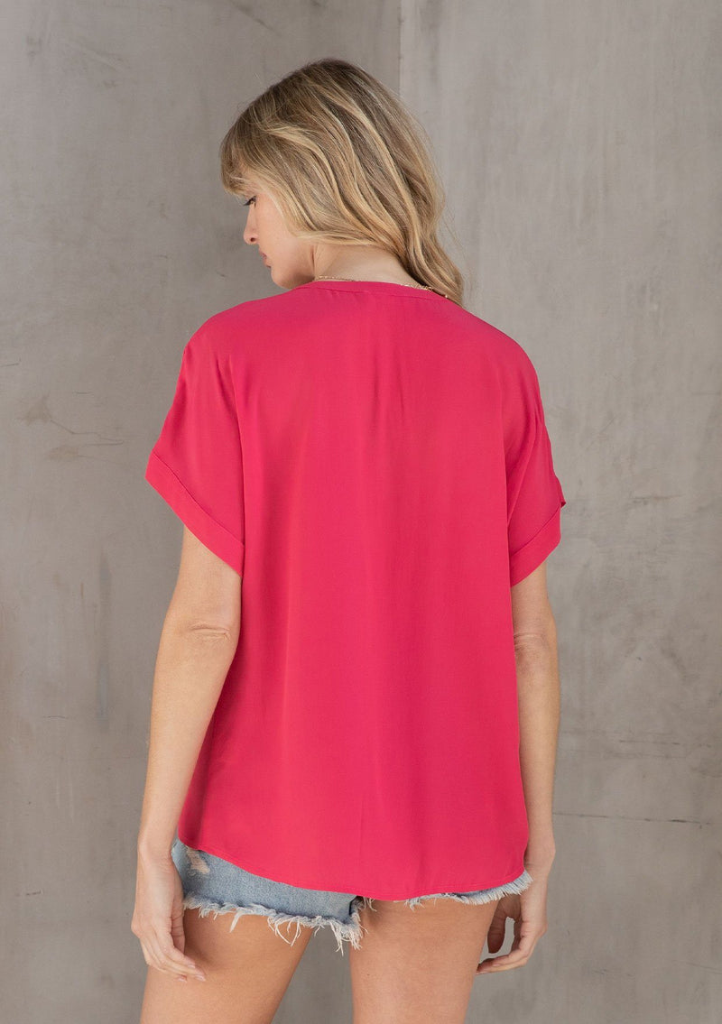 [Color: Watermelon] A model wearing a lightweight bright pink cuffed sleeve top in a soft, silky crepe. With an easy popover silhouette, perfect for work or play. 