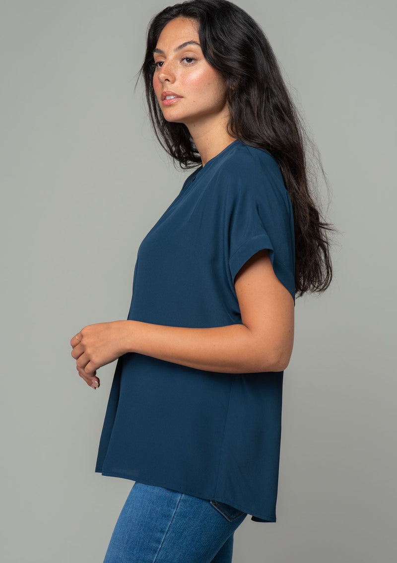 [Color: Midnight] A model wearing a lightweight navy blue cuffed sleeve top in a soft, silky crepe. With an easy popover silhouette, perfect for work or play.