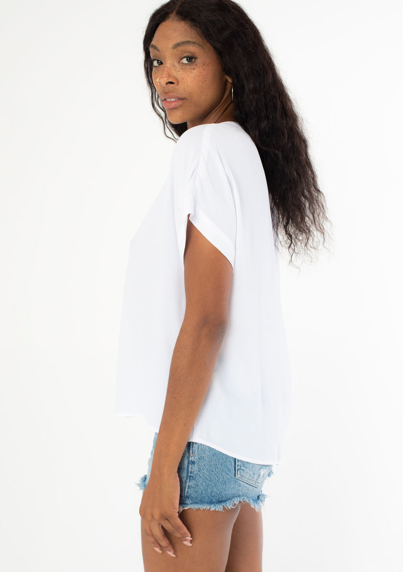 [Color: Chalk] A model wearing a lightweight white cuffed sleeve top in a soft, silky crepe. With an easy popover silhouette, perfect for work or play.
