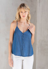 [Color: Vintage Wash] A model wearing a button front camisole in a classic vintage wash blue. Featuring a sexy racerback, a deep v neckline, and a self covered button front. 