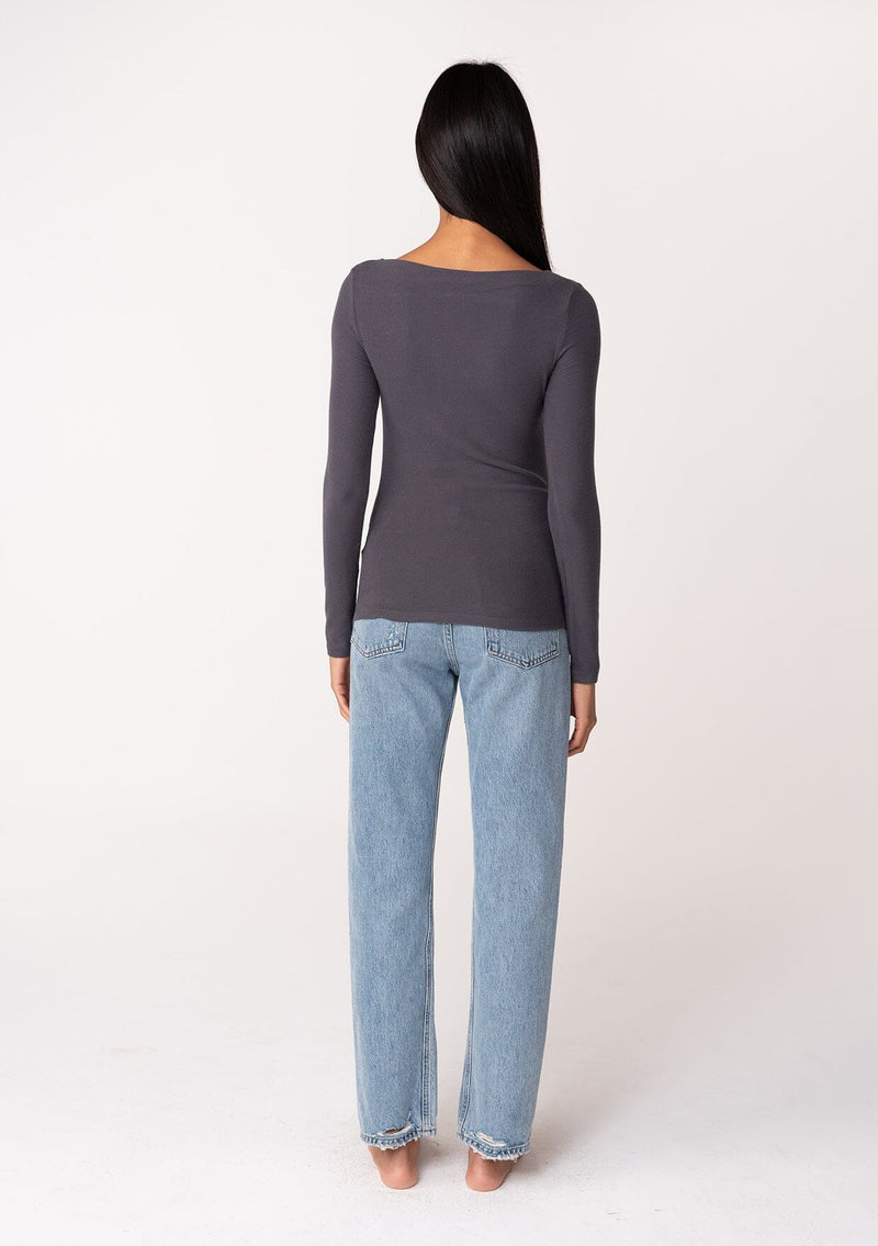[Color: Charcoal] A back facing image of a brunette model wearing a charcoal grey bamboo micro ribbed long sleeve tee. Featuring a mock neckline and a stretchy slim fit.