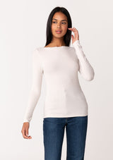 [Color: Nude] A front facing image of a brunette model wearing an off white bamboo micro ribbed long sleeve tee. Featuring a mock neckline and a stretchy slim fit.
