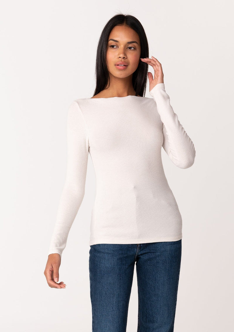 [Color: Nude] A front facing image of a brunette model wearing an off white bamboo micro ribbed long sleeve tee. Featuring a mock neckline and a stretchy slim fit.